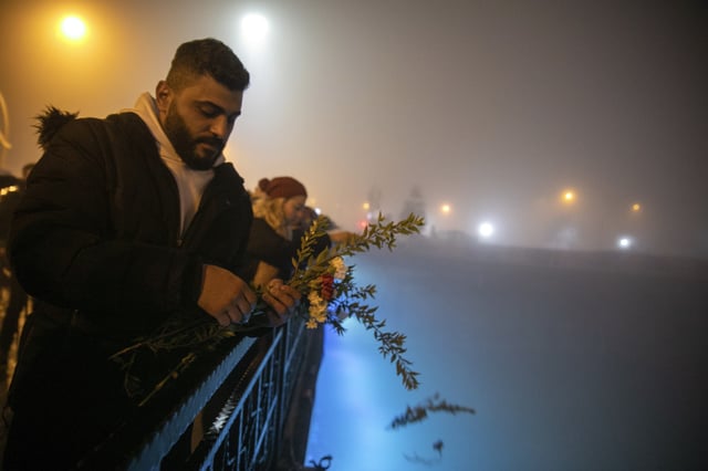 FILE - People toss carnations into the Orontes River as they mark the one-year anniversary of the country's catastrophic earthquake, in the city of Antakya, southern Turkey, Tuesday, Feb. 6, 2024. (AP Photo/Metin Yoksu, File)