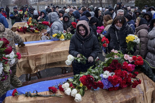 People come to say goodbye to Kateryna Zapishnya, 38, Diana Zapishnya, 12, Danyil Zapishnyi, 8, Serhii Zapishnyi, 40, Dmytro Yavorskyi, 37, Sofia Yavorska, 9, and Olena Yavorska 38, who were killed on Feb. 1 by a Russian strike on residential building during a funeral ceremony in Poltava, Ukraine, Wednesday, Feb. 5, 2025. (AP Photo/Evgeniy Maloletka)