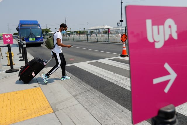 A traveler arriving at Los Angeles International Airport looks for ground transportation in Los Angeles, California, U.S., August 20, 2020. REUTERS/Mike Blake/File Photo