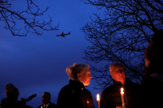A plane flies as people attend a candlelight vigil for the victims of the collision between American Eagle flight 5342 and a Black Hawk helicopter that crashed into the Potomac River near Ronald Reagan Washington National Airport, in Alexandria, Virginia, U.S., February 5, 2025. REUTERS/Eduardo Munoz/File Photo