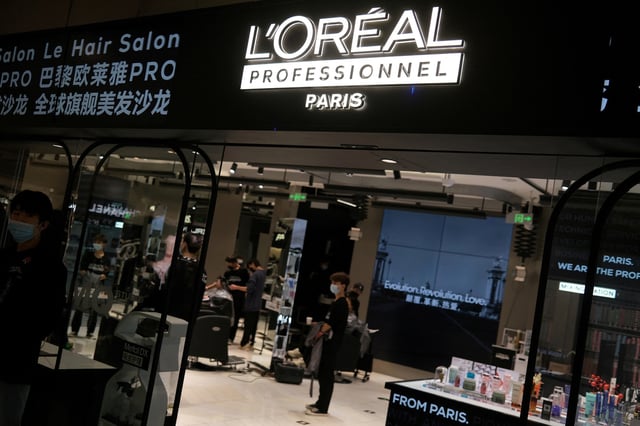 Staff members work at a hair salon of L’Oreal in Beijing, China November 18, 2021. REUTERS/Tingshu Wang/File Photo