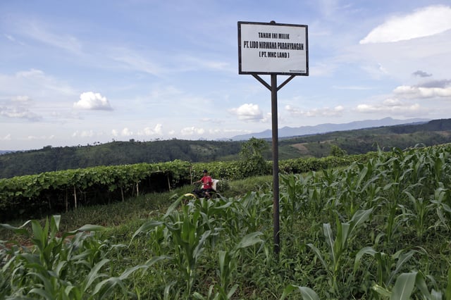 FILE - A sign saying the land is owned by MNC Land is put up on a farming field at the planned development site of a tourism project affiliated with U.S. President Donald Trump, near Gunung Gede Pangrango National Park in Bogor, West java, Indonesia, on March 8, 2017. (AP Photo/Tatan Syuflana, File)