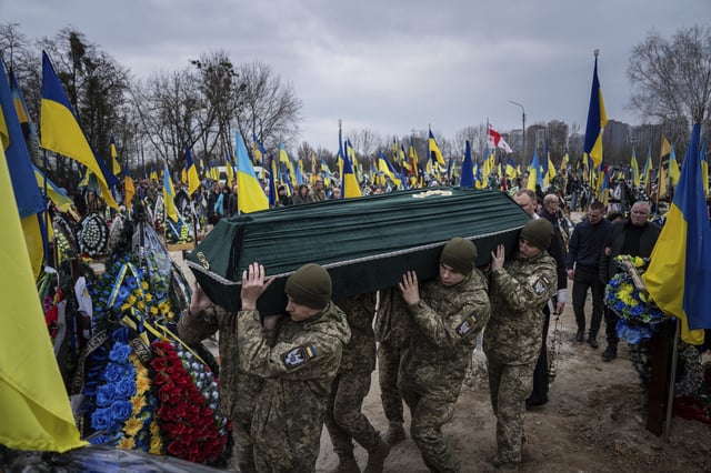 FILE - Ukrainian troops carry the coffin of Andrii Neshodovskiy during his funeral at a cemetery in Kyiv, Ukraine, March 25, 2023. (AP Photo/Evgeniy Maloletka, File)