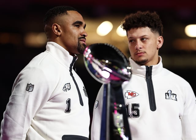 NEW ORLEANS, LOUISIANA - FEBRUARY 3: Jalen Hurts #1 of the Philadelphia Eagles and Patrick Mahomes #15 of the Kansas City Chiefs stand on stage next to the Vince Lombardi Trophy during Super Bowl LIX Opening Night at Caesars Superdome on February 3, 2025 in New Orleans, Louisiana.