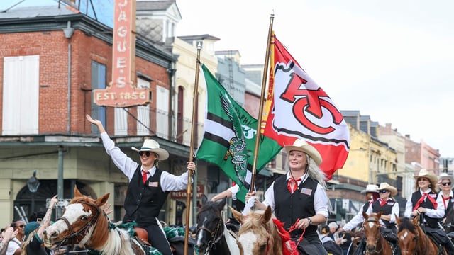 Performers hold Philadelphia Eagles and Kansas City Chiefs flags during the Super Bowl Host Committee Parade on February 08, 2025 in New Orleans, Louisiana. 