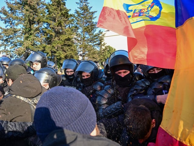 Romanian gendarmes use pepper spray to block protesters who force the protection barrier in front of the Romanian government building in Bucharest on February 10, 2025. Hundreds of supporters of presidential candidate Calin Georgescu gathered in a protest in the front of the government headquarters asking the demission of Ciolacu's gouvernment right after President Iohannis announced his resignation. Romanian President Klaus Iohannis on February 10 announced he would resign following pressure for him to step down ahead of the re-run of an election that was voided over allegations of Russian interference. (Photo by Daniel MIHAILESCU / AFP) (Photo by DANIEL MIHAILESCU/AFP via Getty Images)
