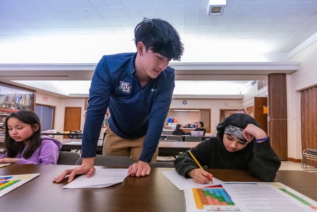 Volunteer Tyler Lowe-Thorpe, a Marquette freshman, assists Burmese refugee middle and high school students attending the Myanmar Learning Center program at Jackson Park Lutheran Church in Milwaukee, WI. on Feb. 8, 2025.