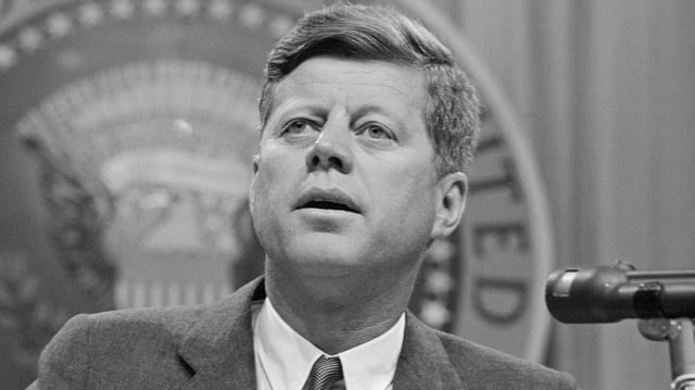 President John F. Kennedy speaking at a conference.
