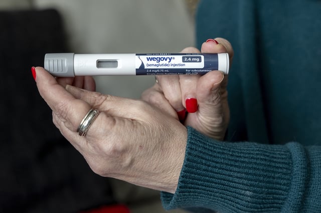 FILE - A woman holds up a dosage of Wegovy, a drug used for weight loss, at her home in Front Royal, Va., on March 1, 2024. (AP Photo/Amanda Andrade-Rhoades, File)