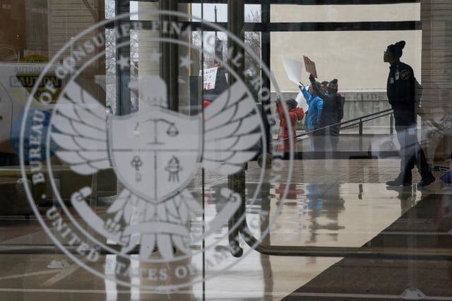 A special police member monitors a protest, while inside the Consumer Financial Protection Bureau (CFPB) building, the day after members of Elon Musk's Department of Government Efficiency (DOGE) moved into the CFPB, in Washington, U.S. February 8, 2025. REUTERS/Nathan Howard/File Photo