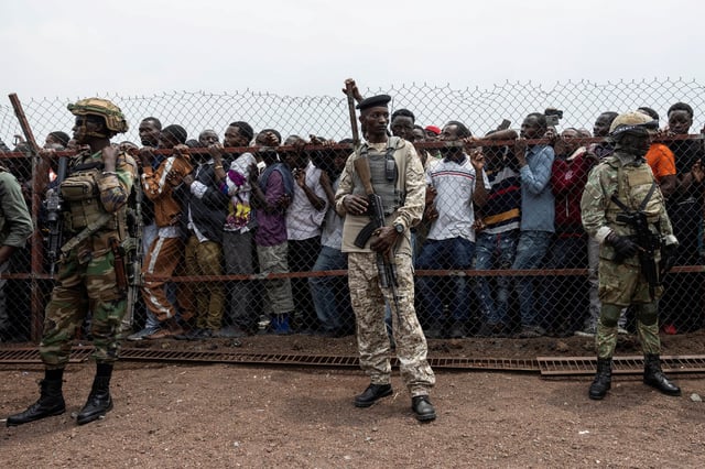 M23 rebels stand guard near civilians during a meeting organised by the M23 at the Stade de l'Unite, after the town of Goma was taken by the M23 rebels, in Goma, Democratic Republic of Congo, February 6, 2025. REUTERS/Arlette Bashizi/File Photo