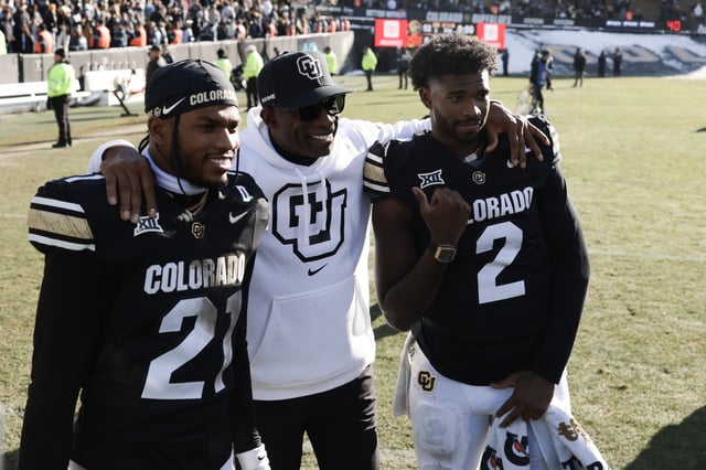 BOULDER, COLORADO - NOVEMBER 29: (L-R) Shilo Sanders #21, Head coach Deion Sanders and Shedeur Sanders #2 of the Colorado Buffaloes pose for a photo after the game against the Oklahoma State Cowboys at Folsom Field on November 29, 2024 in Boulder, Colorado.