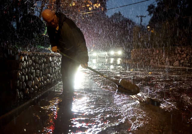 Glenn Lambdin shovels away mud from a mudslide near his home as a powerful atmospheric river storm impacts the region on February 13, 2025 in Sierra Madre, California.