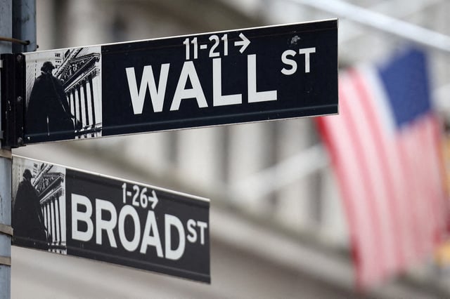 FILE PHOTO: A Wall Street sign hangs in front of a U.S. Flag outside the New York Stock Exchange (NYSE) in New York City, U.S., September 18, 2024. REUTERS/Andrew Kelly/File Photo/File Photo