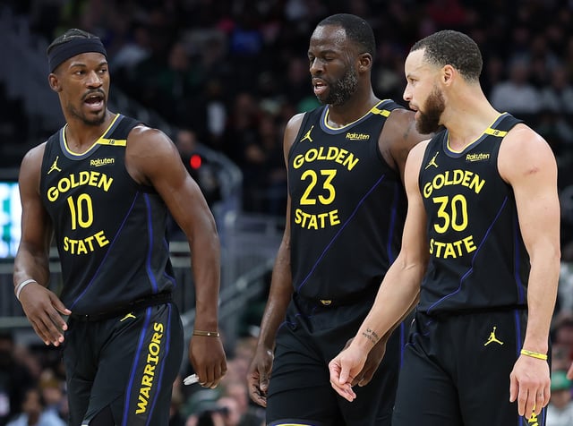 Jimmy Butler #10, Draymond Green #23 and Stephen Curry #30 of the Golden State Warriors walk backcourt during a game against the Milwaukee Bucks at Fiserv Forum on February 10, 2025 in Milwaukee, Wisconsin.