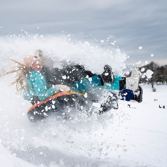 Children toboggan down a hill following heavy snow in Toronto, Thursday, Feb. 13, 2025. THE CANADIAN PRESS/Arlyn McAdorey