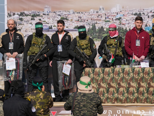 Israeli hostages Iair Horn, 46, left, Sagui Dekel Chen, 36, center left, and Alexander Troufanov, 29, right, are escorted by Hamas and islamic Jihad fighters as they are handed over to the Red Cross in Khan Younis, Gaza Strip, Saturday, Feb. 15, 2025. (Abdel Kareem Hana/AP)