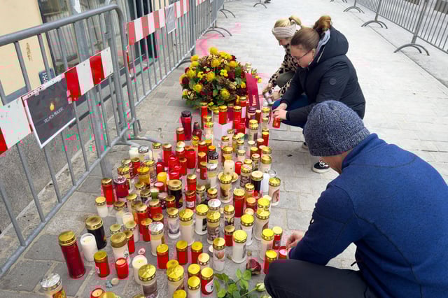 People light candles at the site of the stabbing a day after an attack that left a 14-year-old dead and five others injured, in Villach, Austria, Sunday.