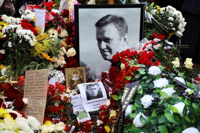 La tombe du leader de l’opposition russe Alexei Navalny alors que des personnes en deuil viennent marquer le premier anniversaire de sa mort dans un cimetière à Moscou, Russie, le 16 février 2025.