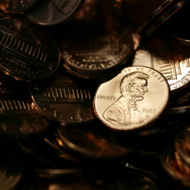 FILE - A lone penny is illuminated in a bin of completed pennies at the U.S. Mint in Denver, Aug. 15, 2007. (AP Photo/David Zalubowski)
