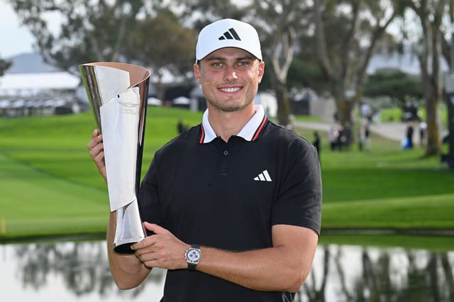 Ludvig Aberg holds up the trophy after winning The Genesis Invitational golf tournament at Torrey Pines.
