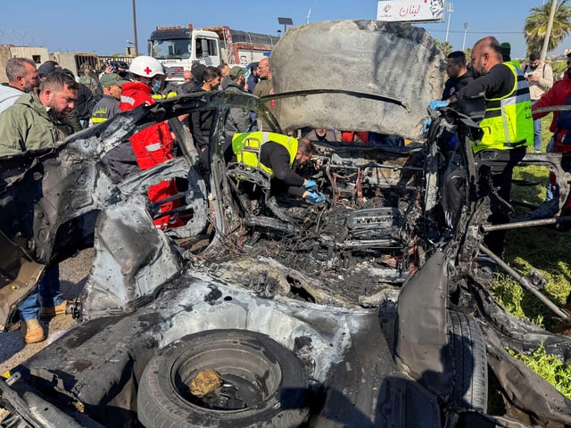 Members of civil defence inspect a damaged car after an Israeli strike, according to security sources, at the southern port city of Sidon, Lebanon, February 17, 2025. REUTERS/Ali Hankir
