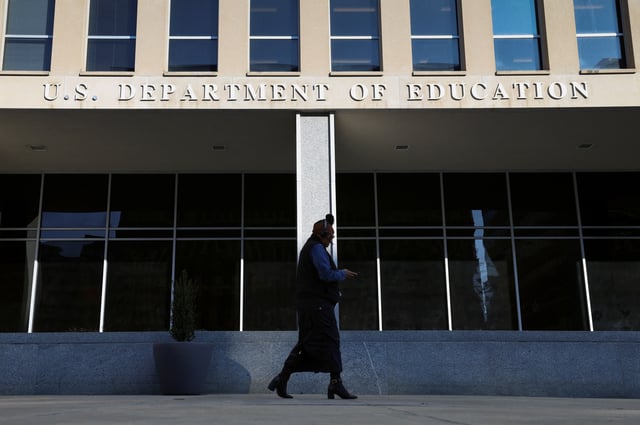 A person walks in front of the Department of Education building, amid reports that U.S. President Donald Trump's administration will take steps to defund the federal Education Department, in Washington, U.S., February 4, 2025. REUTERS/Kevin Lamarque/File Photo