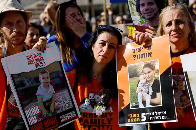 Une femme porte des pancartes avec des images d’Ariel Bibas, qui est détenu à Gaza depuis l’attaque mortelle du 7 octobre 2023