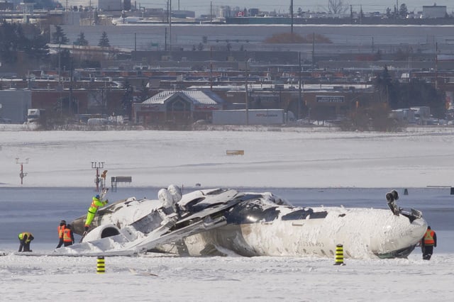 The wreckage of a Delta Air Lines operated CRJ900 aircraft lies on the runway following a crash at Toronto Pearson International Airport in Mississauga, Ontario, Canada February 18, 2025. REUTERS/Cole Burston