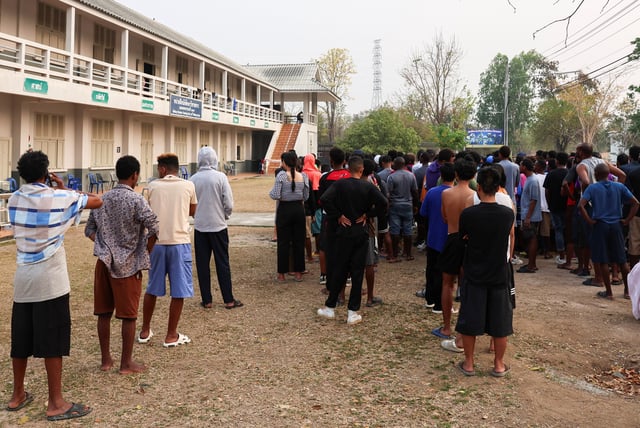 Multinational victims of scam centres, who were trafficked into working in Myanmar and were sent to Thailand on February 12 amid a mounting crackdown on scam centres operating along a porous border, queue to get food at a shelter inside the 310th Military District (Fort Wachiraprakan), as they wait for their embassies to pick them up, in Tak province, Thailand February 19, 2025. REUTERS/Chalinee Thirasupa