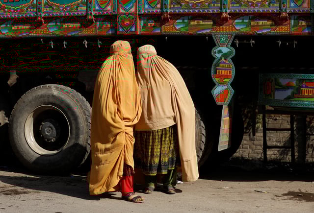 Afghan women in burqa stand with a truck loaded with belongings as they return home, after Pakistan gives last warning to undocumented immigrants to leave, outside the United Nations High Commissioner for Refugees (UNHCR) repatriation centre in Azakhel town in Nowshera, Pakistan November 3, 2023. REUTERS/Fayaz Aziz/File Photo