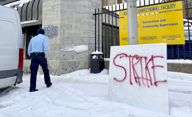 A corrections officer walks into Auburn Correctional Facility while several dozen coworkers strike across the street in Auburn, N.Y., Tuesday, Feb. 18, 2025 to protest unsafe working conditions.