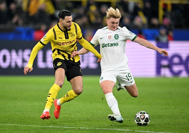 Soccer Football - Champions League - Knockout Phase Playoff - Second Leg - Borussia Dortmund v Sporting CP - Signal Iduna Park, Dortmund, Germany - February 19, 2025 Borussia Dortmund's Ramy Bensebaini in action with Sporting CP's Conrad Harder REUTERS/Jana Rodenbusch