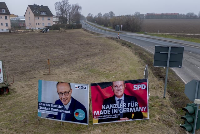 FILE - Election posters, showing German Chancellor Olaf Scholz, right, and CDU top candidate Friedrich Merz, stand on a meadow in Nieder-Erlenbach near Frankfurt, Germany, Feb. 5, 2025. (AP Photo/Michael Probst, File)