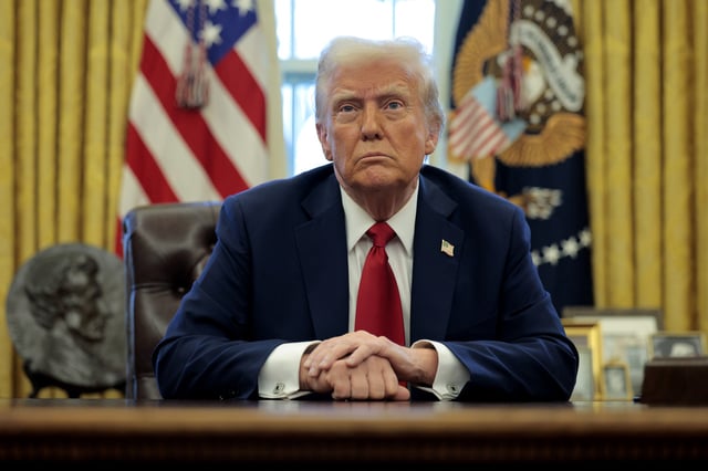 President Donald Trump talks to reporters from the Resolute Desk after signing an executive order to appoint the deputy administrator of the Federal Aviation Administration in the Oval Office at the White House on January 30, 2025 in Washington, DC.
