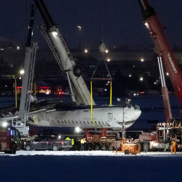 Cranes lift the wreckage of Delta Flight 4819 from the runway onto a truck at Toronto Pearson International Airport, in Mississauga, on Feb. 19.