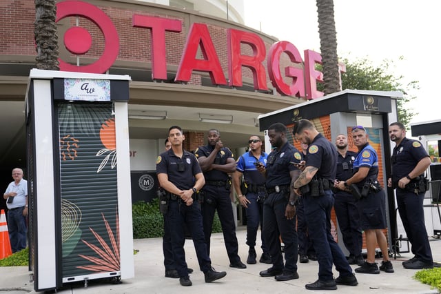 FILE - Police stand outside a Target store as protesters across the street demonstrate against Pride displays in the store on June 1, 2023, in Miami. (AP Photo/Lynne Sladky, File)