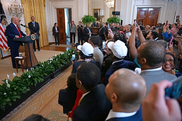 President Donald Trump speaks alongside US golfer Tiger Woods during a reception for Black History Month in the East Room of the White House on February 20, in Washington, DC.