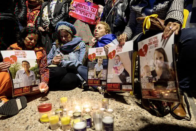 Des Israéliens se recueillent devant les portraits des otages décédés Oded Lifschitz, Shiri Bibas et ses deux enfants, Kfir et Ariel Bibas, enlevés lors de l’attaque mortelle du 7 octobre 2023 par le Hamas.