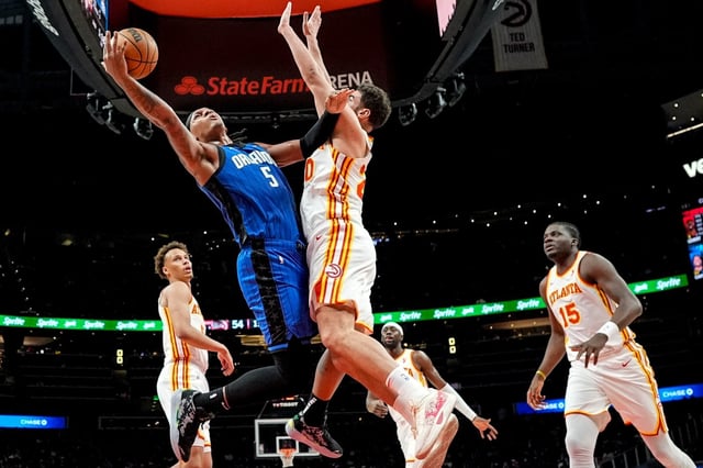 Orlando Magic forward Paolo Banchero (5) shoots against Atlanta Hawks forward Georges Niang (20) during the first half of an NBA basketball game, Thursday, Feb. 20, 2025, in Atlanta. (AP Photo/Mike Stewart)