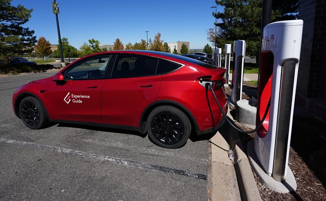 FILE - A Tesla Model 3 charges at a Tesla supercharging station situated in the parking lot of an outlet mall on Sept. 25, 2024, in Lakewood, Colo. (AP Photo/David Zalubowski, File)