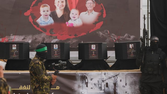 Coffins containing the remains of Ariel and Kfir formed the centrepiece of a ghoulish parody of a ceremony