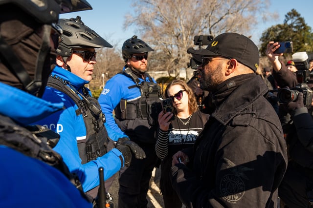 De facto leader of the Proud Boys Enrique Tarrio, right, speaks with Capitol Police Officers after they separated a protester from the group after a press conference outside the U.S. Capitol on Friday, Feb. 21, 2025.