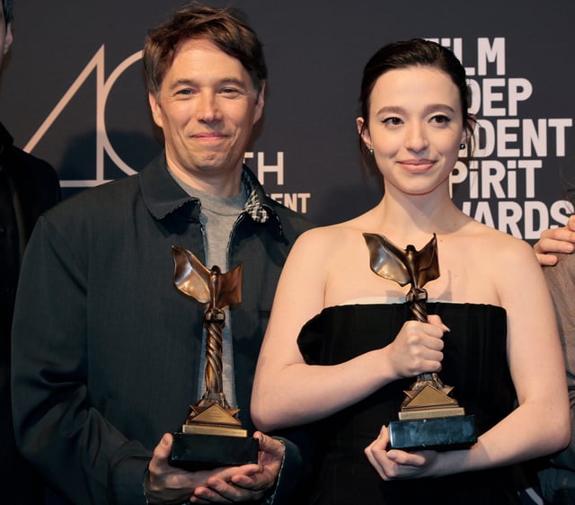 Sean Baker and Mikey Madison pose backstage with their trophies at the 40th Independent Spirit Awards.