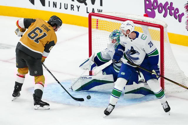 Feb 22, 2025; Las Vegas, Nevada, USA; Vegas Golden Knights right wing Mark Stone (61) shoots against Vancouver Canucks goaltender Kevin Lankinen (32) in front of Vancouver Canucks defenseman Marcus Pettersson (29) during the third period at T-Mobile Arena. Mandatory Credit: Stephen R. Sylvanie-Imagn Images