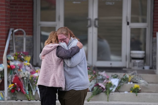 Leah Fauth receives a hug after leaving flowers in front of the West York Police Department, after a police officer was killed responding to a shooting at UPMC Memorial Hospital in York, Pennsylvania, on Saturday.