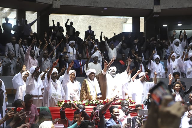 Delegates sing during a planned signing ceremony of the Sudan Founding Charter aimed at establishing a unity government involving leaders of political forces, armed groups, and the Rapid Support Forces (RSF) at the Kenyatta International Convention Centre (KICC) in Nairobi, Tuesday, Feb. 18, 2025. (AP Photo/Andrew Kasuku)