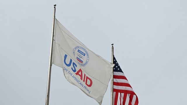 A USAID and American flag flag fly outside the USAID building in Washington DC on February 3, 2025.