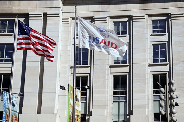 An American flag and USAID flag fly outside the USAID building in Washington, D.C., U.S., February 1, 2025. REUTERS/Annabelle Gordon/File Photo