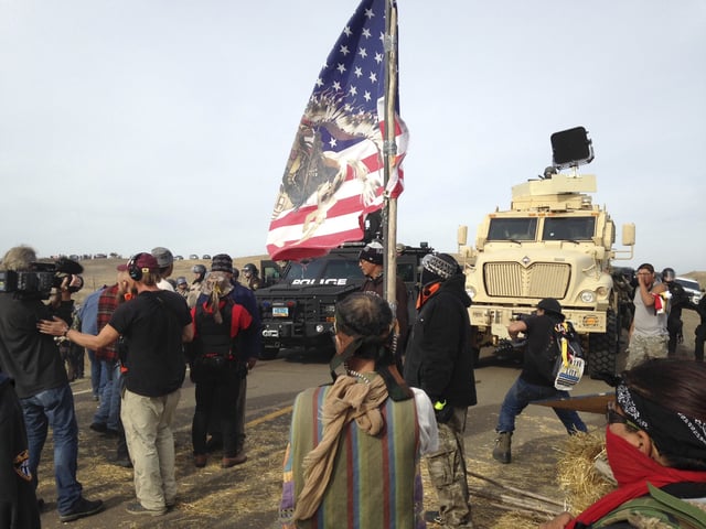 FILE - Dakota Access pipeline protesters defy law enforcement officers who are trying to force them from a camp on private land in the path of pipeline construction, Oct. 27, 2016, near Cannon Ball, N.D. (AP Photo/James MacPherson, File)